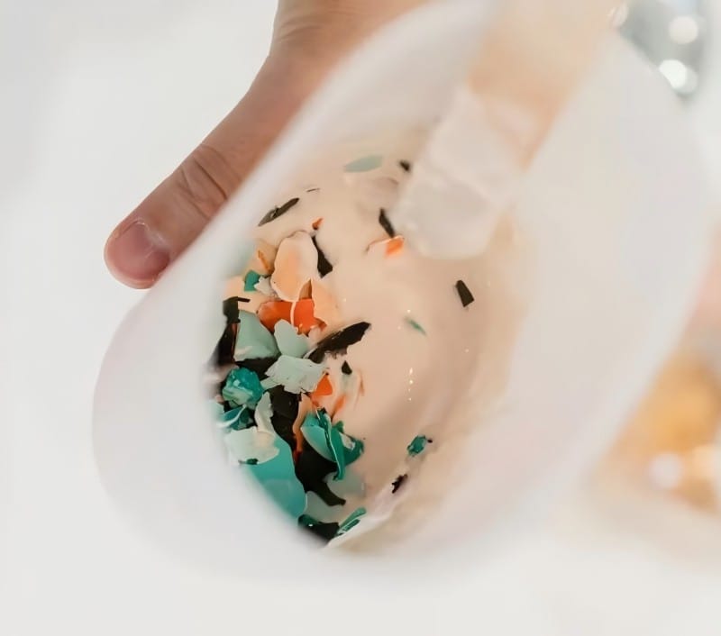 Close-up of colorful broken plastic pieces mixed in a container