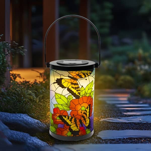 Cylindrical stained-glass style solar lantern with butterfly and floral design, portable handle