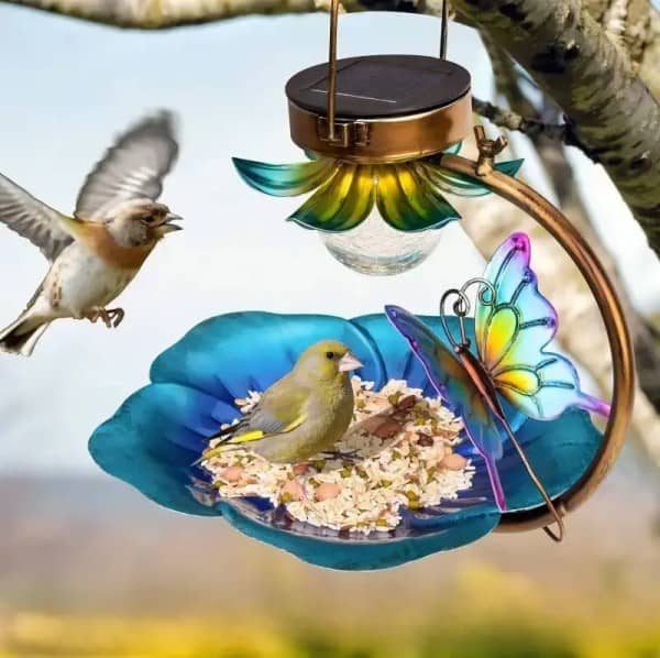 solar powered bird feeder with butterfly design in a garden